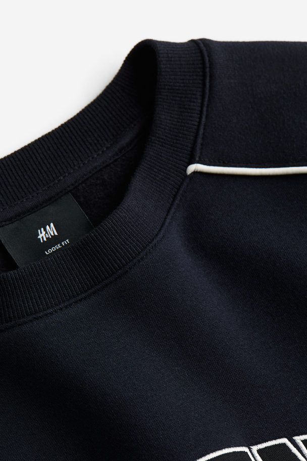 H&M Sweatshirt mit Motivstickerei in Relaxed Fit Schwarz/Queens