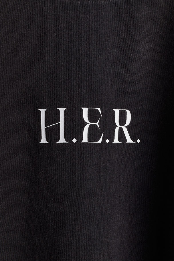 H&M Oversized T-Shirt mit Print Schwarz/H.E.R.
