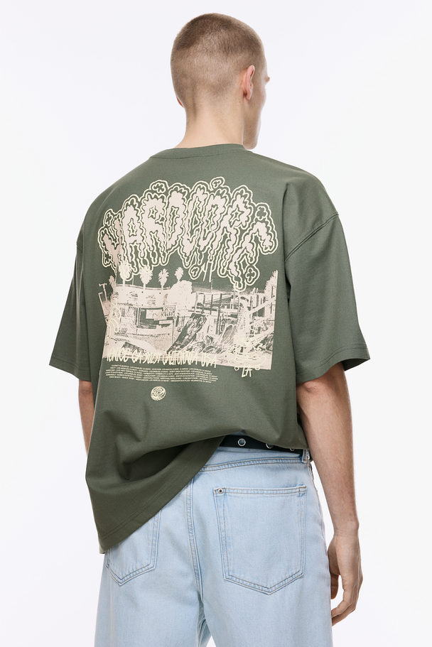 H&M Bedrucktes T-Shirt in Oversized Fit Khakigrün/Hardcore