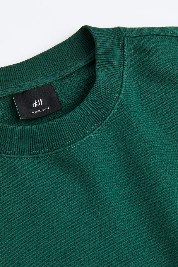 H&M Sweatshirt mit Print Oversized Fit Dunkelgrün/Boring Pals