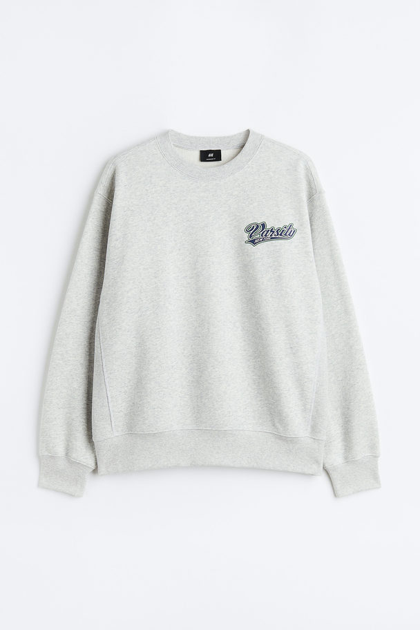 H&M Sweatshirt mit Print Oversized Fit Hellbeigemeliert/Varsity