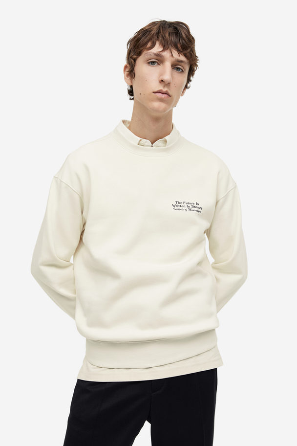 H&M Bedrucktes Sweatshirt in Loose Fit Cremefarben/Stones