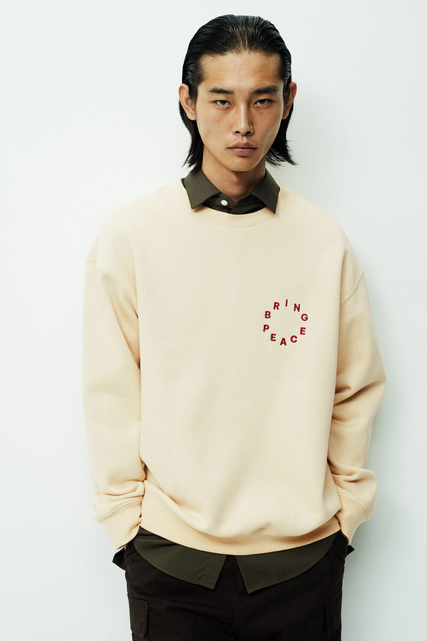 H&M Bedrucktes Sweatshirt in Loose Fit Beige/Bring Peace