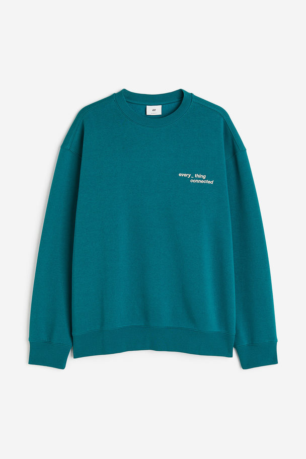 H&M Bedrucktes Sweatshirt in Loose Fit Blaugrün/Connected