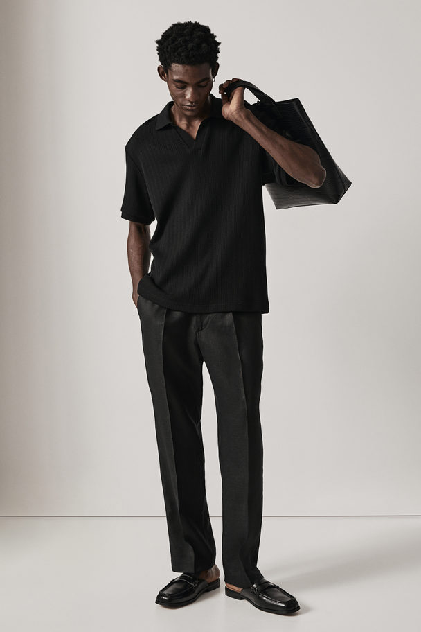 H&M Poloshirt mit Lochmuster in Regular Fit Schwarz