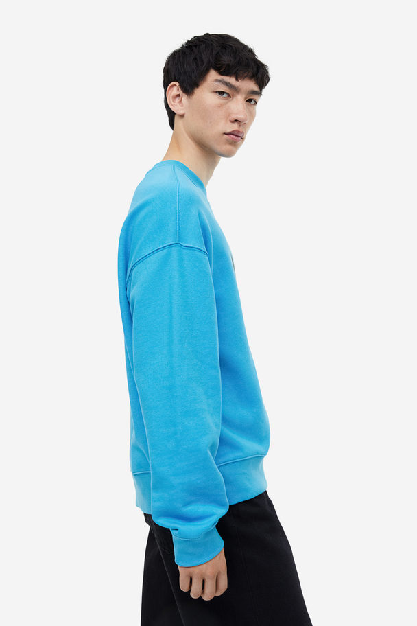 H&M Sweatshirt mit Print Relaxed Fit Blau/Harlem